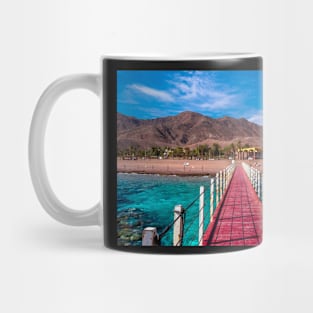 Beach bridge with colorful desert behind. Red sea Israel Mug